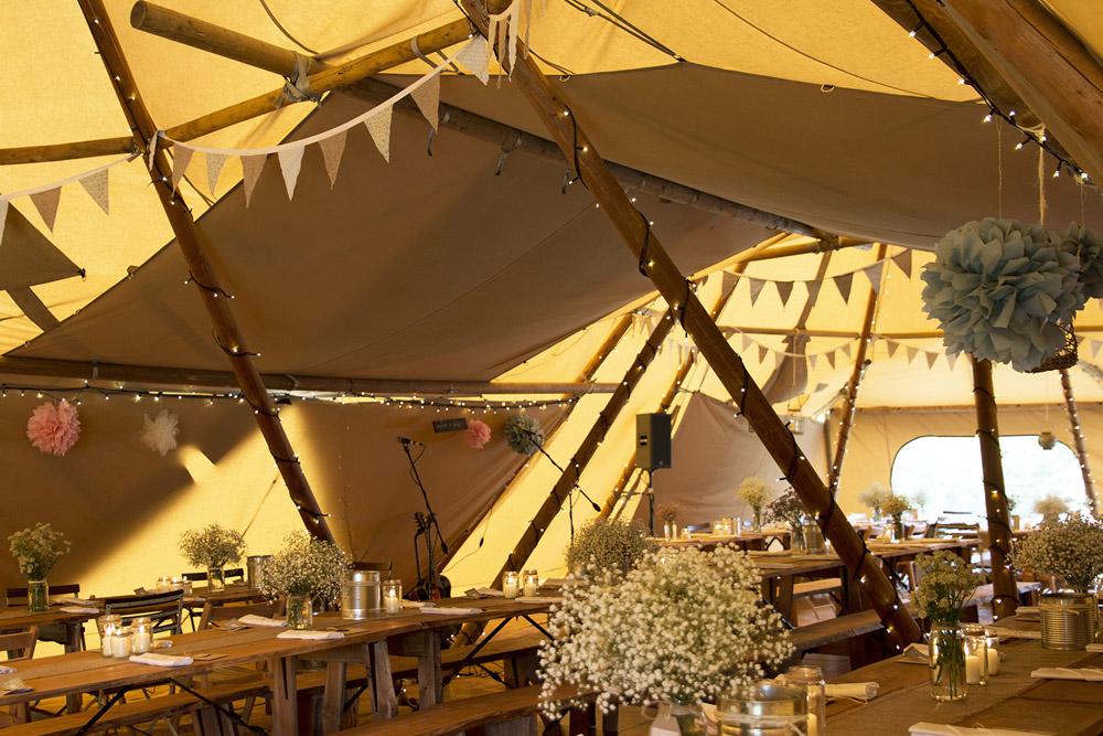 Inside a tipi with tables and chairs. Located in Essex